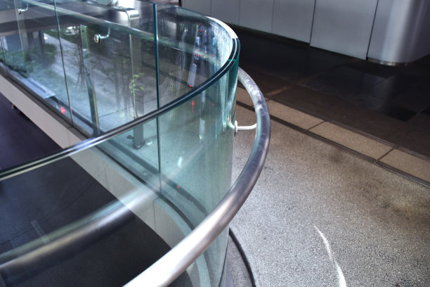 曲线钢化夹胶玻璃栏杆栏杆板框少，适用于现代建筑建筑安全玻璃。铝阳台或露台的概念设计与玻璃型材。公司和行业组合形象。图片下载