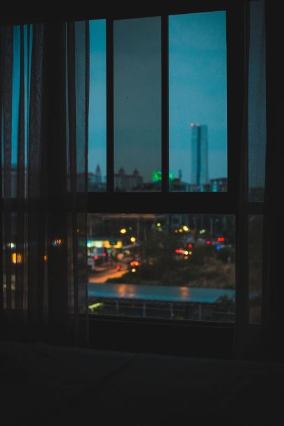 从一间黑暗房间的窗户垂直拍摄夜晚的城市灯光图片下载