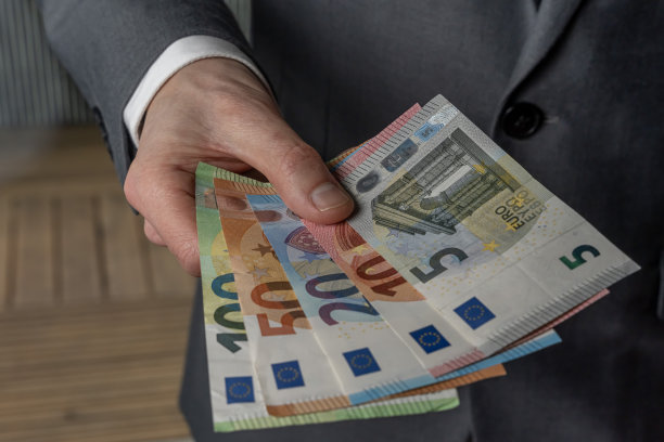 法国巴黎- 02 03 2023:静物。一名身着西装的男子手里拿着不同面额的欧元钞票图片下载