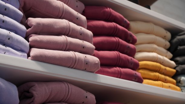 服装店货架上堆放着不同颜色和尺寸的布料图片下载