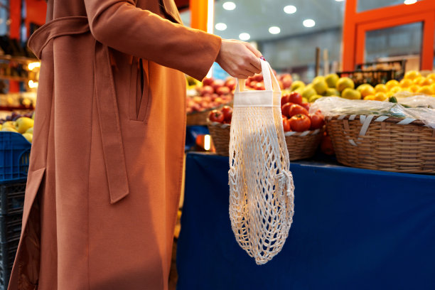 一个女人在农贸市场挑选水果和蔬菜的特写图片下载