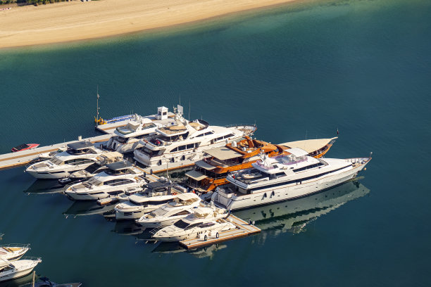 在靠近海滩的码头上停泊着快艇和豪华游艇。从上面看。图片下载