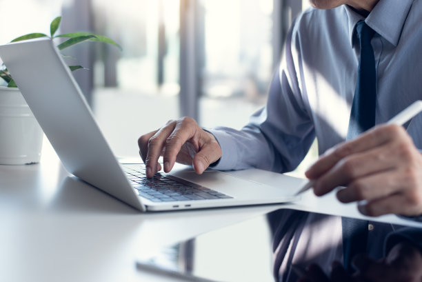 商务人士用笔记本电脑办公，用办公桌上的平板电脑上网，分析商业报告。图片下载