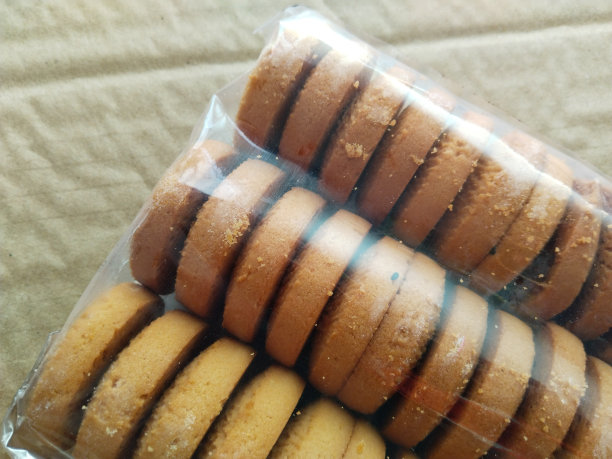 在棕色背景上包装饼干。塑料包装的饼干。复制空间，放置你的文字图片下载