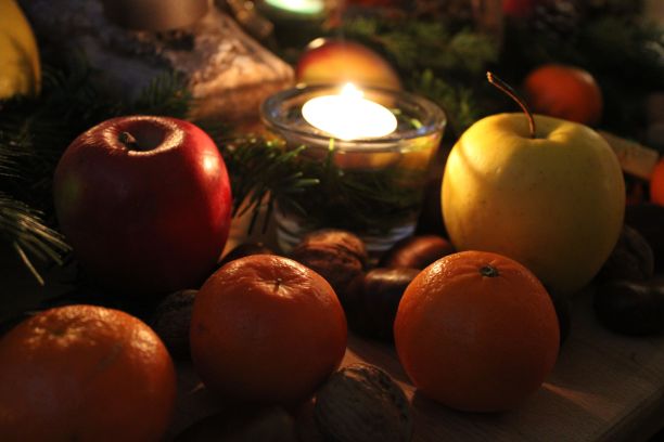 特写镜头的彩色水果和蜡烛在桌子中央装饰冷杉叶图片下载