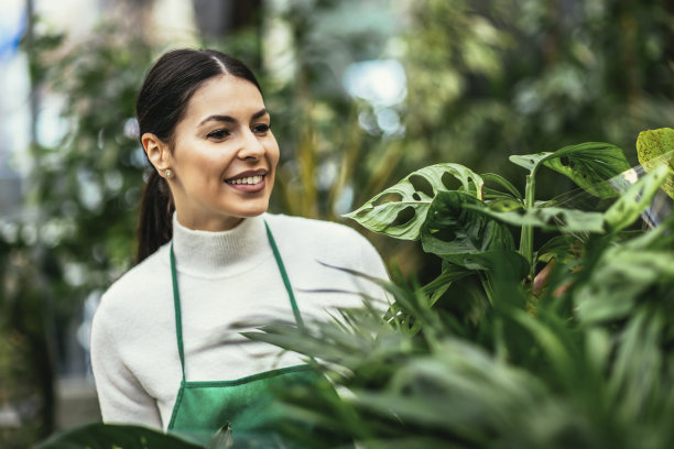 美丽的花匠在花店工作和照顾植物的肖像图片下载