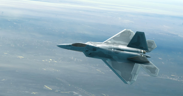 战斗机飞过云层之上的城市。准备空袭。图片下载