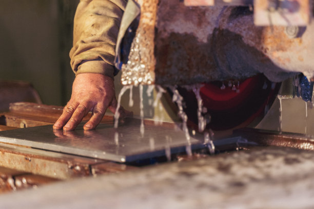 一个男性用机器切割瓷砖的特写镜头图片下载