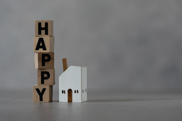 用木块配上文字HAPPY与白木家居模型。为年轻家庭提供住房的概念图片下载
