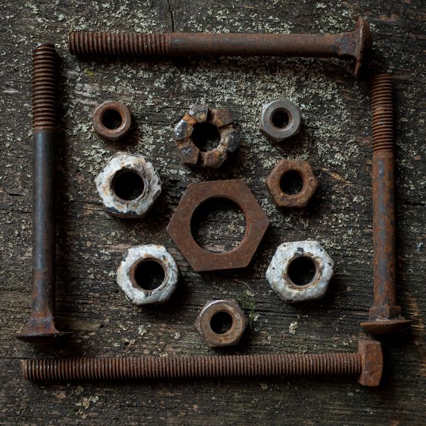 顶部视图的生锈和旧螺母螺栓和螺丝放在grunge表表面图片下载