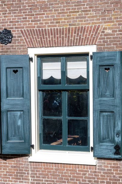 垂直拍摄的白色窗户和砖墙上的蓝色百叶窗图片下载