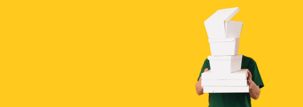 横幅大小拍摄在黄色背景的一个送餐员拿着饭盒。图片下载