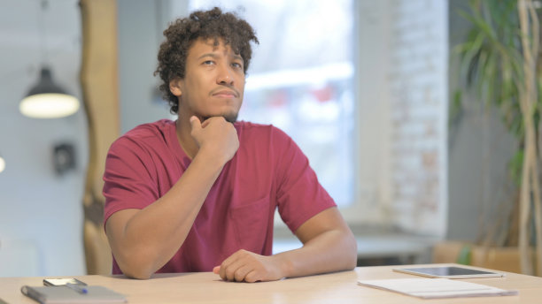 沉思的非洲男人在工作时思考图片下载