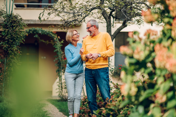 老夫妇拿着钥匙站在他们的新家外面图片下载
