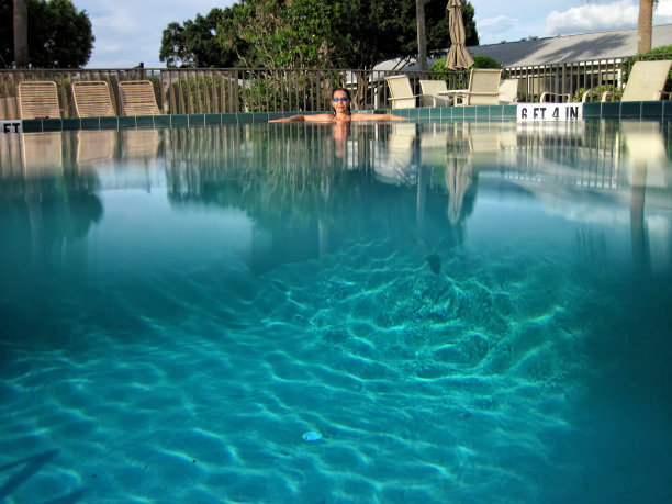 美丽的年轻女子在游泳池放松图片下载