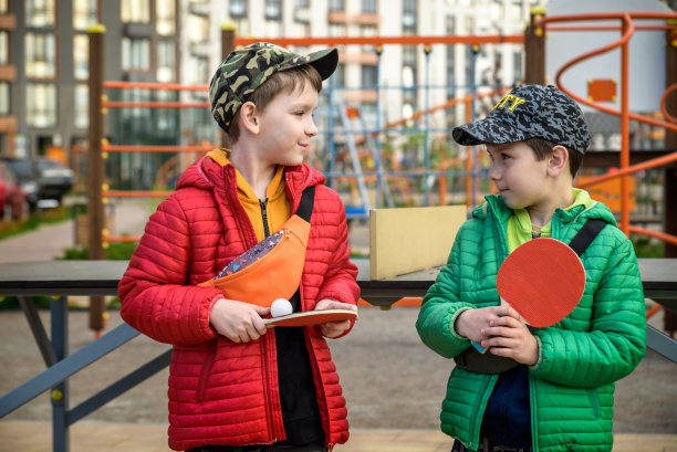 两个快乐的男孩，十几岁的双胞胎兄弟，享受假期在户外打乒乓球。儿童积极休闲理念图片下载