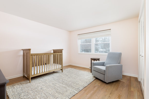 有粉红色墙壁和木制婴儿床的育婴室。图片下载