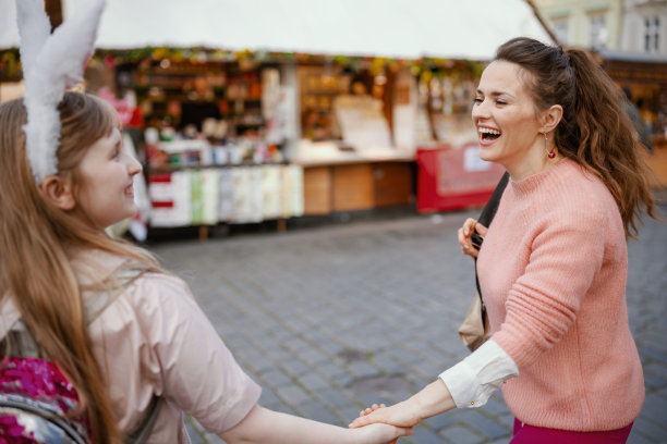 微笑的现代母亲和孩子走在城市集市图片下载