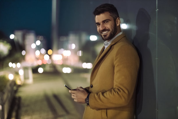经理晚上在户外使用智能手机图片下载