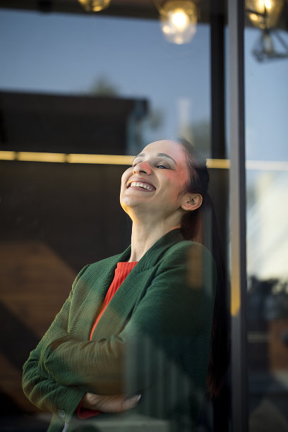 微笑的女人看向别处与双臂交叉图片下载