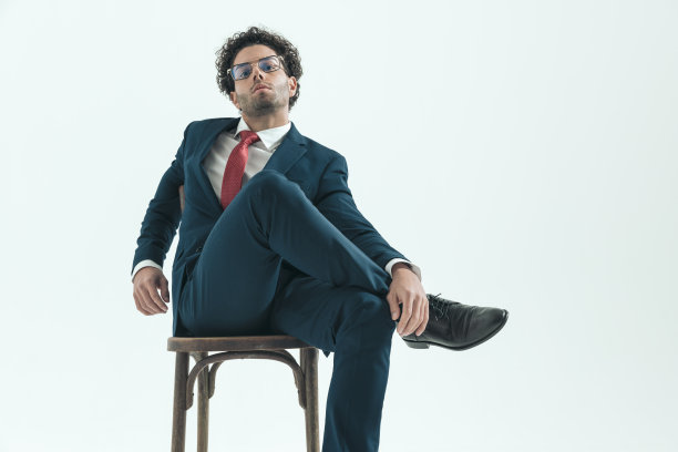 商人跷二郎腿，举起一只脚图片下载