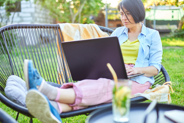 自由职业妇女在后院用笔记本电脑工作图片下载