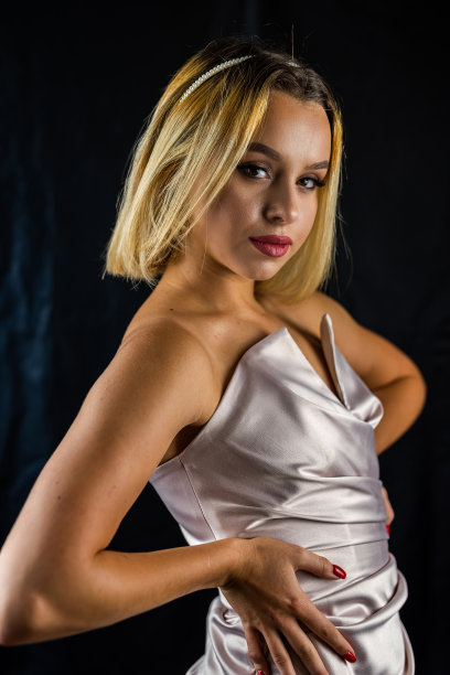 性感优雅的性感女孩在诱人的睡衣摆姿势在一个简单的黑暗背景。图片下载