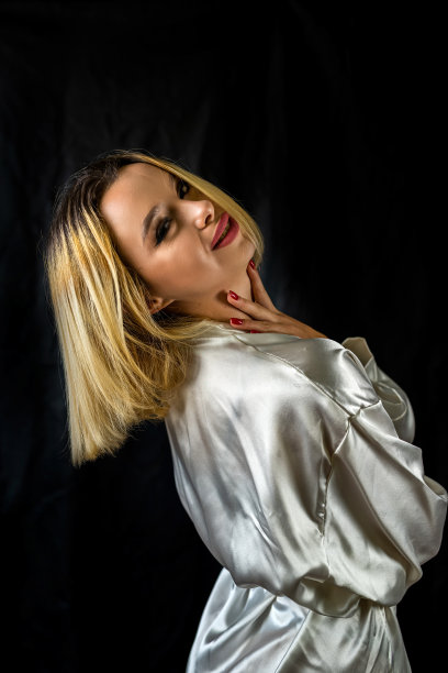 性感优雅的性感女孩在诱人的睡衣摆姿势在一个简单的黑暗背景。图片下载