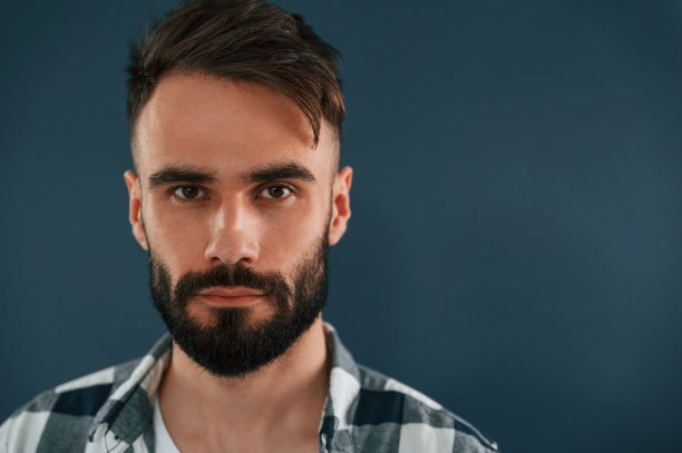 特写肖像。英俊的男人在蓝色背景的演播室里图片下载