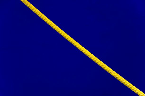 黄色聚酯船用系泊绳，衬着丰富的饱和蓝色船体图片下载