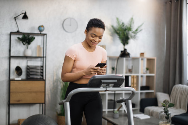 迷人的年轻体育非洲妇女使用手机，而工作图片下载