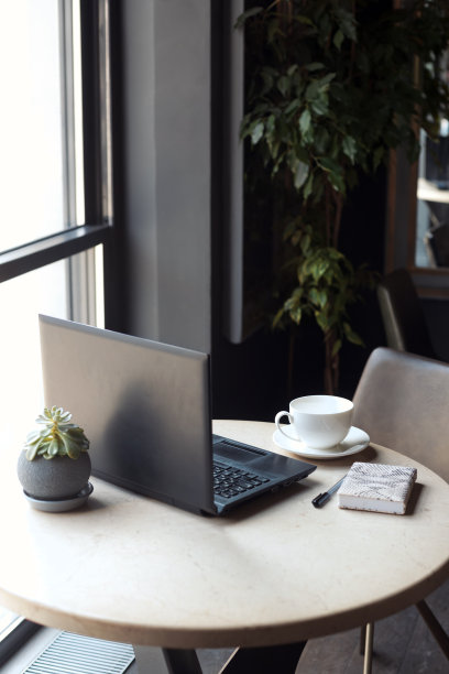 时尚的深色办公室内饰。办公地点的大理石桌子，电脑放在窗边。没有人图片下载