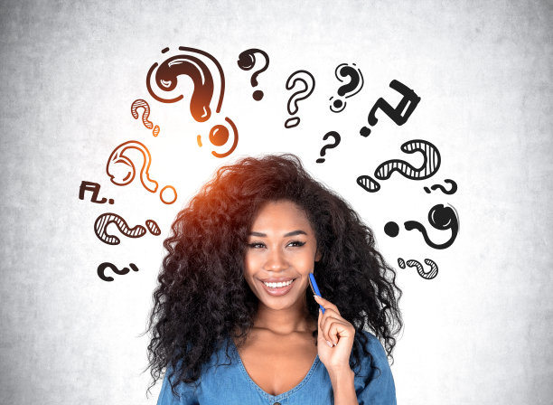 一个非洲女人，带着梦幻般的神情，灰色的墙上挂着问号图片下载