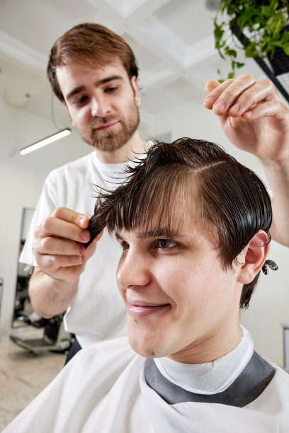 理发师坐在椅子上与白人男子交谈图片下载