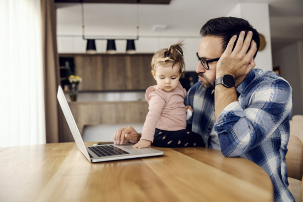 一个过度劳累的父亲和工人试图完成报告，而他的女儿打扰他。图片下载