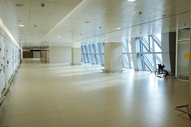 一个现代化的机场，宽敞空旷的灯光走廊和角落里的轮椅图片下载