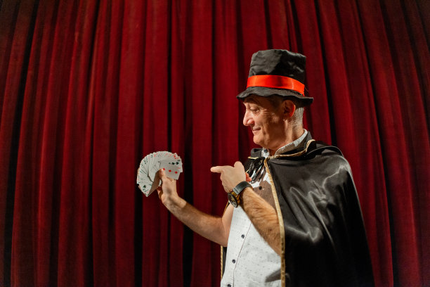 男魔术师在舞台上用扑克牌表演魔术图片下载