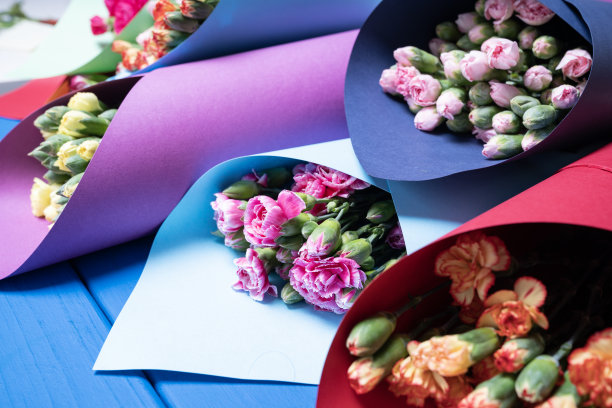 办公桌上五颜六色的康乃馨花束的特写照片图片下载