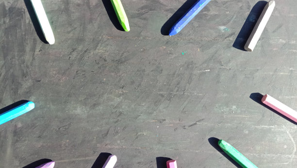 彩色蜡笔与书旁边的照片，黑色背景图片下载