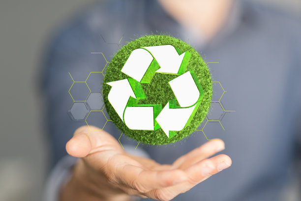 这个人的手的特写三维渲染的绿色星球与回收图标。图片下载