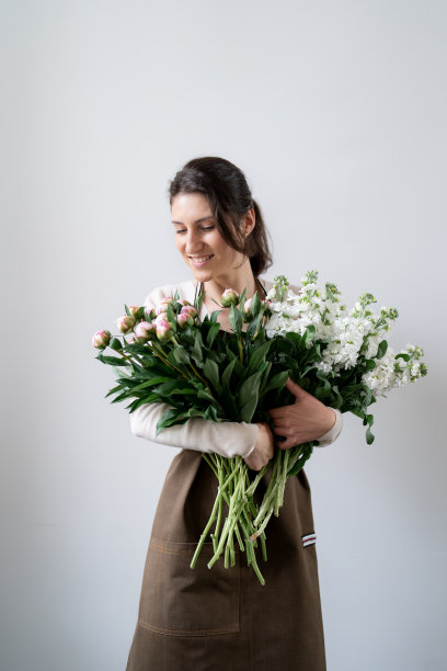 一位女士抱着一束白色背景的花图片下载