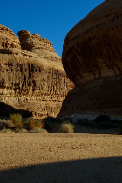 沙特阿拉伯Hegra阳光明媚的干燥沙漠中岩石山脉的竖版照片图片下载