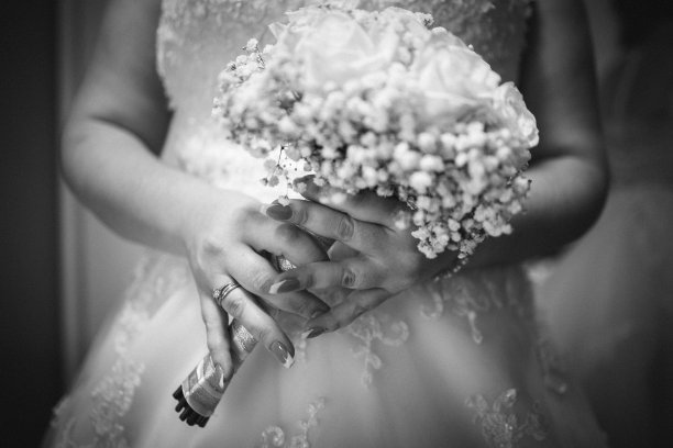 特写镜头的新娘拿着一束花在灰度图片下载