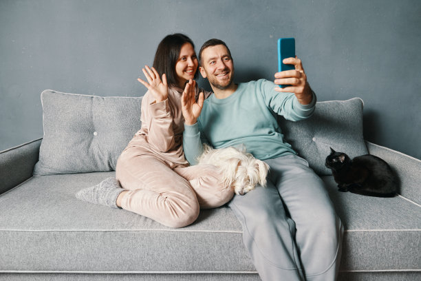 幸福微笑的情侣在使用智能手机应用程序的在线视频通话中问候朋友图片下载