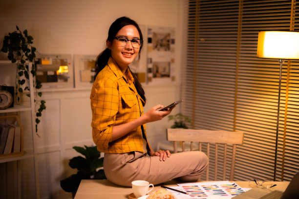 年轻漂亮的女人在衬衫工作晚从家里在客厅深夜加班。女商人在工作场所低头看电脑。图片下载