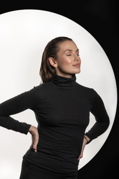 女子穿着黑色高领毛衣，紧身裤子和湿头发风格的工作室肖像图片下载