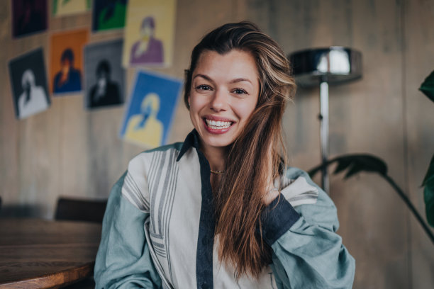 可爱的白人女人坐在咖啡馆里看着相机露齿微笑。近距离肖像的西班牙女孩在休闲娱乐周末在酒吧。青年和休闲活动。快乐的女人。图片下载