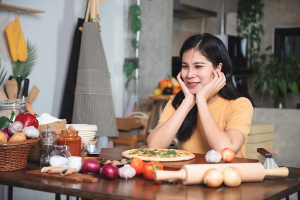 美丽的亚洲女人穿着围裙在家里厨房准备和制作食物。小型商业餐厅和美食。图片下载