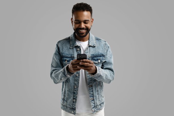 英俊、兴奋、快乐、愉快的家伙，穿着休闲的衣服，给他的情人发送和接收信息，孤立在白色背景下图片下载