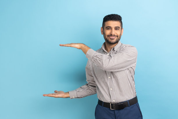 乐观的络腮胡商人展示广告区域，对着镜头露出灿烂的笑容图片下载